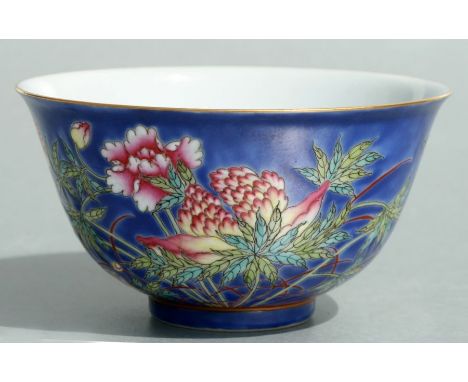 A Chinese famille rose bowl decorated with chrysanthemums and birds on a blue ground, red seal mark to the underside and bear