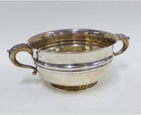 George V silver twin handled punch bowl, London 1919, with leaf clasped S scroll handles and circular footrim, 32cm across th