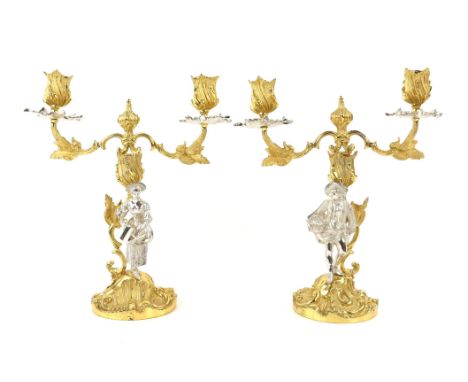 A pair of Mappin and Webb Rococo style silver gilt 2 branch figural candelabra modelled as a woman with watering can and a ma