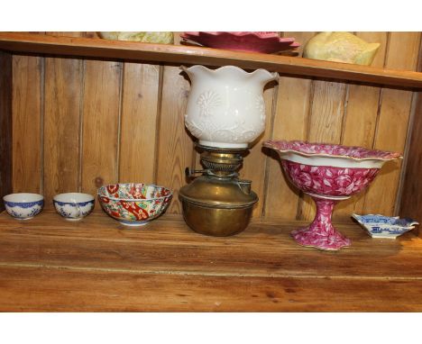 A Chinese porcelain tea bowl, Japanese Imari dish, 19th century blue and white print dish (a/f), a pink glazed pedestal bowl,