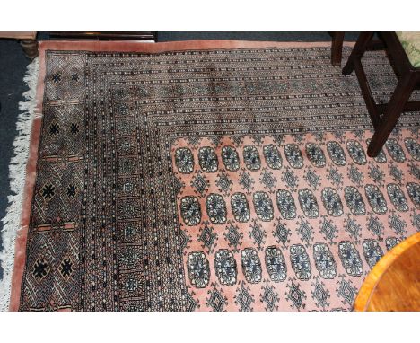 A Pakistani Kayam wool carpet, pink ground with central elephant foot pattern inside square borders 280cm by 380cm