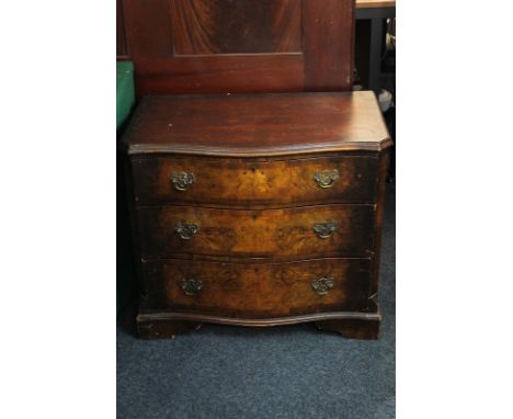 A 20th century walnut serpentine chest of three drawers on bracket base, 77cm