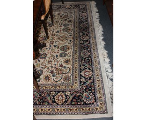 An Indian wool carpet, cream ground with overall floral and scroll pattern 295cm by 252cm