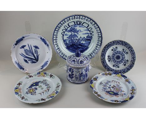 A Delftware circular pot and cover with mask mounts, a pair of plates (repaired), a bowl, 28cm, and two other blue and white 