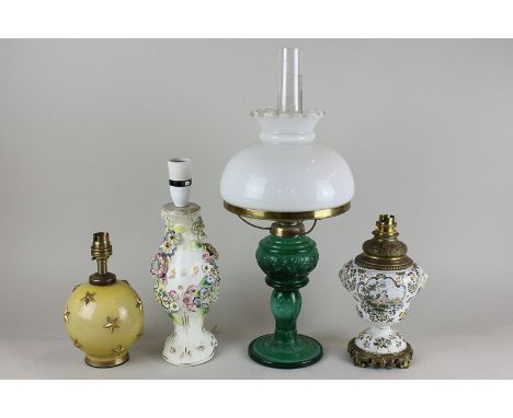 A green glass oil lamp with funnel and opaque glass shade, 49cm high, and three various table lamps