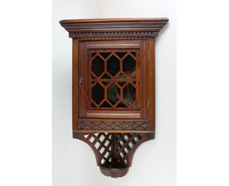 A small mahogany corner cabinet with panel glazed door and fret work under shelf, 68cm high