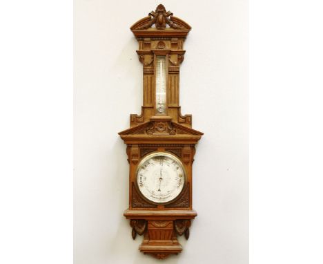 A large late Victorian aneroid barometer, c.1880, with carved oak architectural case, and silvered dial, 36 x 105cm, together