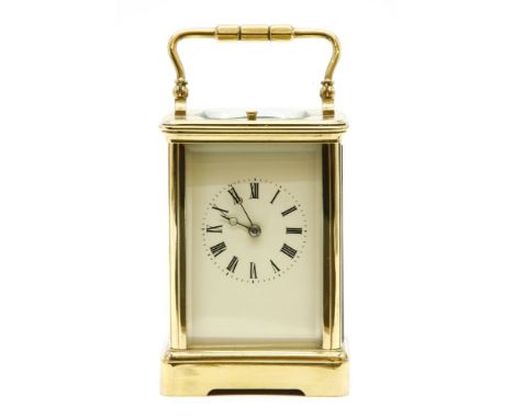 An early 20th century repeating brass carriage clock, with bevelled glass sides and top, 16cm high to the top of the handle
