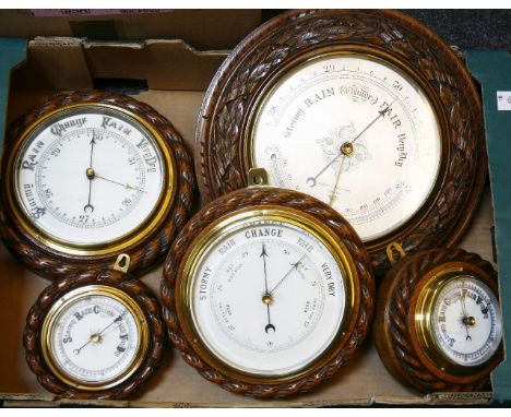 A Victorian aneroid barometer, by Negretti & Zambra, the silvered dial, with addition of a thermometer, in a carved oak frame