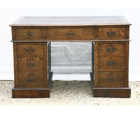 An Edwardian oak twin pedestal desk, each pedestal with three drawers, 121cm wide, 67cm deep, 74cm high