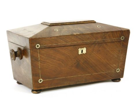 A Regency mahogany tea caddy, of sarcophagus form, decorated all over with boxwood stringing and brass inlay, the lid lifting