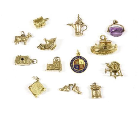 Thirteen gold charms, including a 9ct gold church, a 9ct gold ark, a 9ct gold camera, an amethyst seal fob, and a 9ct gold sp