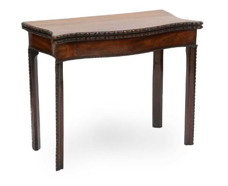 A George III Mahogany Foldover Card Table, late 18th century, of serpentine-shaped form, with carved border and hinged leaf e