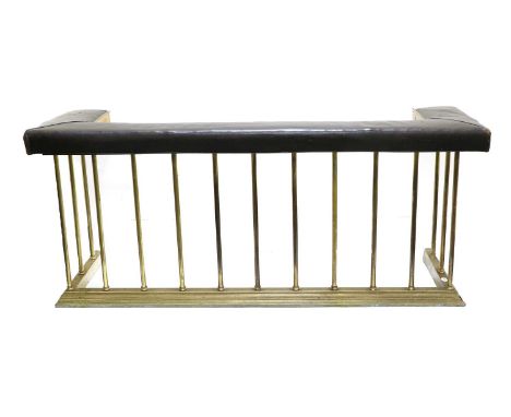 A Brass Club Fender, early 20th century, covered in worn black leather, with padded seat above tubular supports and kerb base