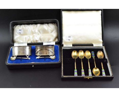 Stokes & Ireland Ltd. A pair of cased oval silver salts, Chester 1914, with blue glass liners, and a pair of silver condiment