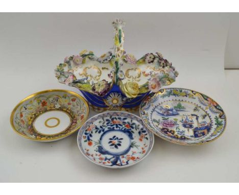 A late 19th century floral encrusted porcelain bon-bon basket, and three porcelain saucers