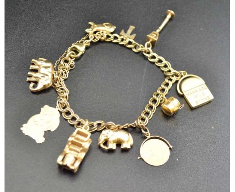 A 9ct gold charm bracelet, bearing 9ct gold and yellow metal charms, including a whistle, car, elephants, lamp post etc. gros