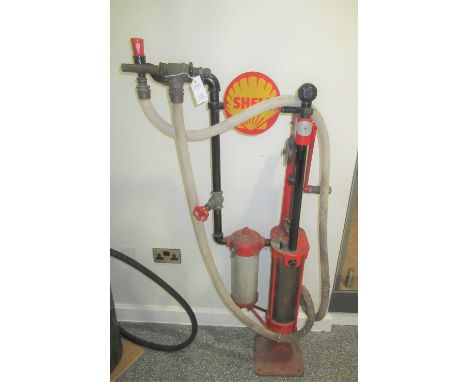 A Vintage Red Painted Skeleton Petrol Pump, later painted red and black, with a fabric-covered rubber hose and brass tap, 140