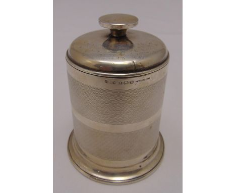 A hallmarked silver engine turned cigarette caddy of cylindrical form, the pull off cover with spool finial on circular sprea
