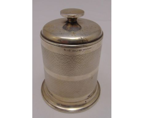 A hallmarked silver engine turned cigarette caddy of cylindrical form, the pull off cover with spool finial on circular sprea