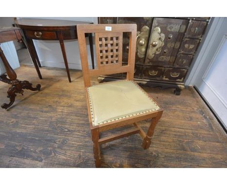 A set of six Robert "Mouseman" Thompson oak dining chairs, c. 1970, each with lattice back over a hide seat and raised on fac