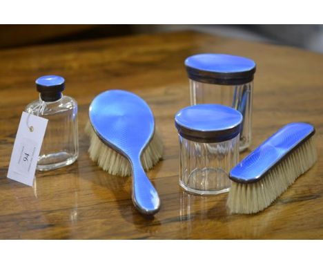 A George V silver and enamel matched partial dressing table set, Birmingham 1928 and 1929, comprising three jars and two brus