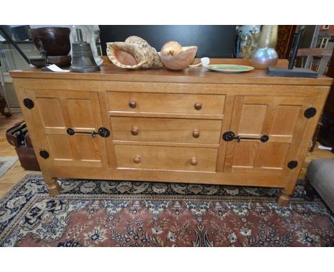 A Robert "Mouseman" Thompson oak 5' sideboard, c. 1970, the rectangular adzed top with ledge back and cut-off corners above a
