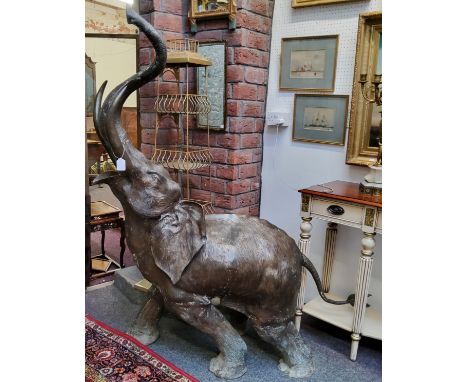 Indian School, a brown patinated bronze, a large elephant, with trunk raised, cast with stylised headress and naturalistic gr