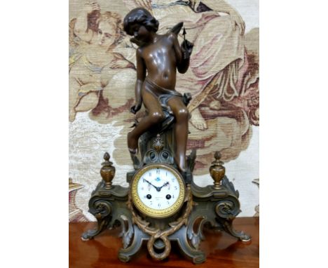 An early 20th century spelter figural mantel clock, surmounted with cherub, elaborate acanthus scrolled details, the cabbage 