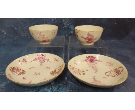 A pair of Worcester&nbsp; tea bowls and saucers,&nbsp; painted in Meissen style with puce camaieu flowers, in gilt panels, c.