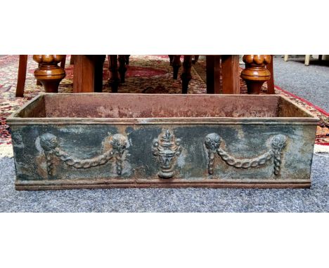 A Neo Classical type cast iron planter, heavy gauge, decorated in relief with ribbon tied swags 