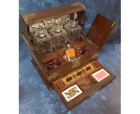 A late Victorian oak tantalus cabinet, three hobnail cut&nbsp; decanters, hinged twin covers enclosing compartments two holdi