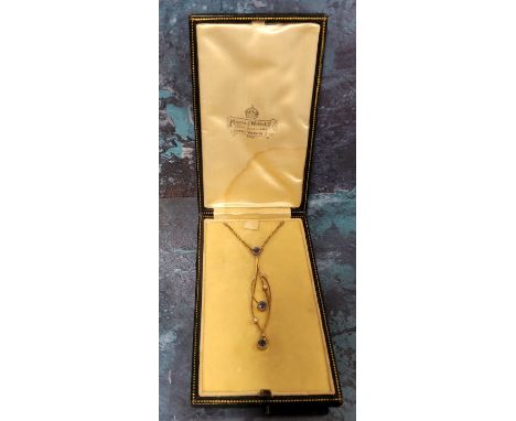 An Art Nouveau yellow metal, sapphire &amp; seed pearl drop pendant of sinuous form, collet set with three round Ceylon sapph