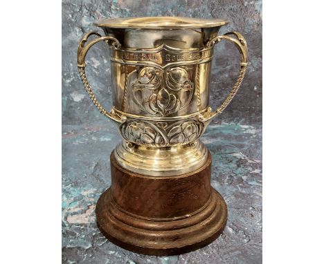 An Edwardian silver three handled trophy tyg, embossed with Art Nouveau stylised buds and scrolls, divided loop handles, insc