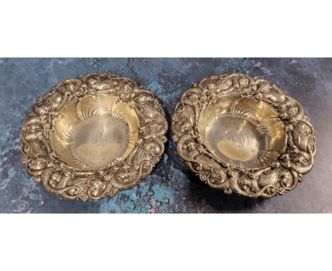 A pair of American Art Nouveau sterling silver shaped circular dishes, embossed with scrolling leaves and buds, 14.5cm diam, 