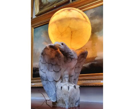 An impressive Art Deco Italian alabaster table lamp in the form of a golden eagle, surmounted with a two-section spherical gl