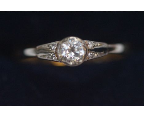 18ct Gold solitaire diamond ring, diamond flanked by four smaller diamonds to shoulders. Size P.5