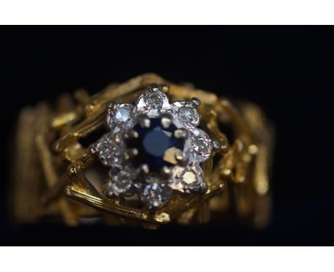 Yellow metal ring tested for high carat set with central sapphire surrounded by 8 diamonds. Size O 