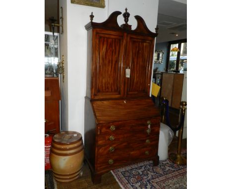 A George III and later mahogany bureau bookcase with swan neck pediment over two panel doors, fall front and four graduated l