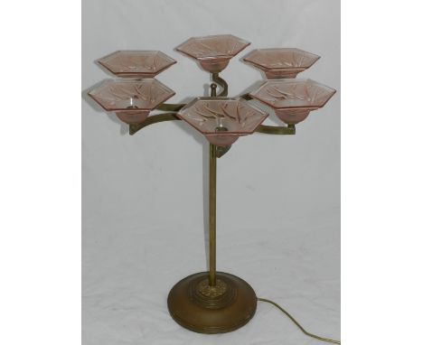 An Art Deco table lamp, having three demi lune shaped braches, each with pink hexagonal glass shades, raised on brass base an