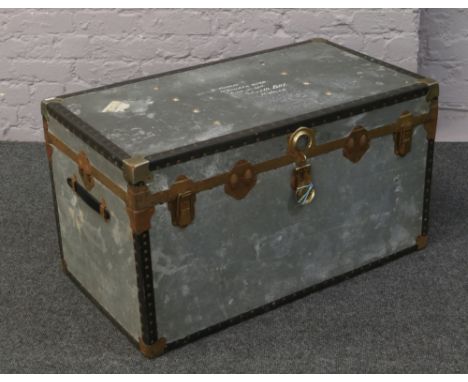 A galvanised metal bound tin trunk with twin handles.
