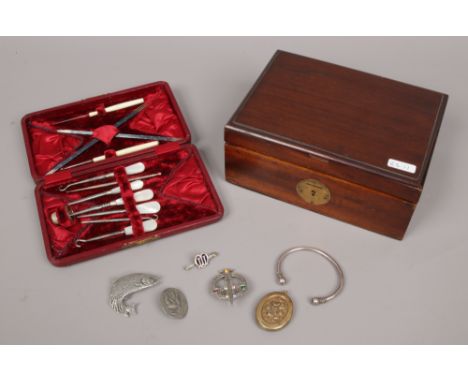 A mahogany jewellery box with contents of costume jewellery along with a cased manicure set with mother of pearl handled exam