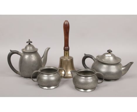 A Tudric Pewter four part tea service Liberty &amp; Co. along with a brass hand bell.