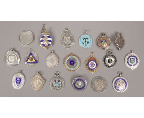 A collection of silver medals and badges to include enamel examples.