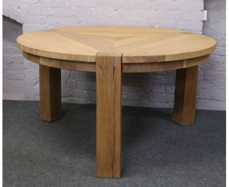 A large light oak circular Helcinky rustic dining table and a natural wood care kit.