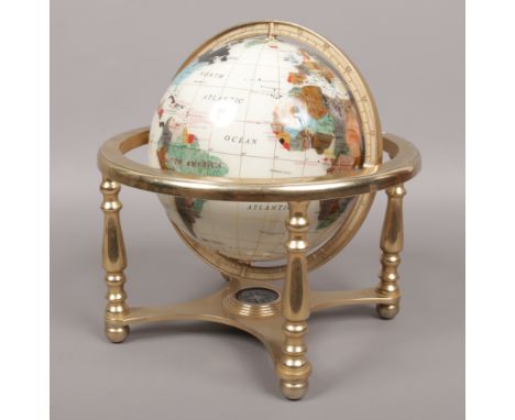 A revolving table globe and compass to base raised on a turned brass stand.