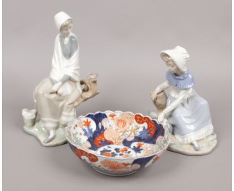 A Nao figure of a young girl with kitten along with damaged Lladro figure of a seated girl and a Japanese Imari bowl.