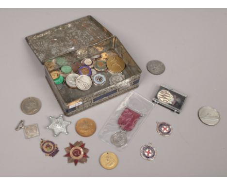 A tin of various medals to include enamel examples.