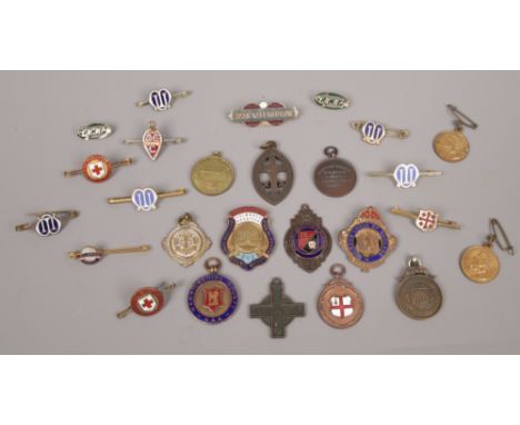 A collection of medals and badges to include enamel examples.