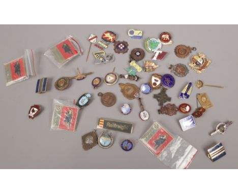 A box of various medals and badges to include enamel examples.